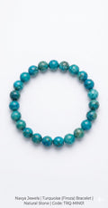 Close up of natural turquoise gemstone bracelet showing unique blue patterns and polished beads